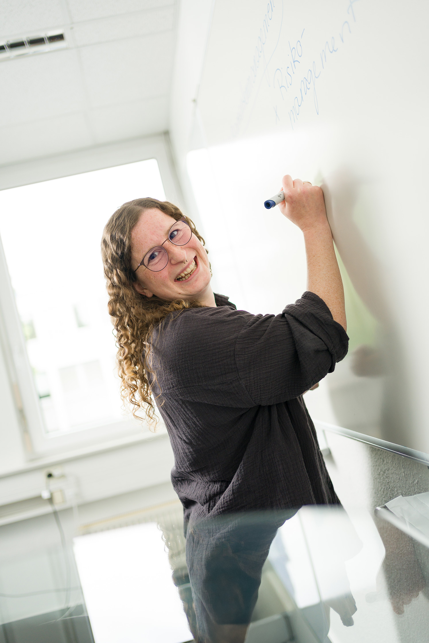 Glückliche Auszubildende schreibt auf einem Whiteboard