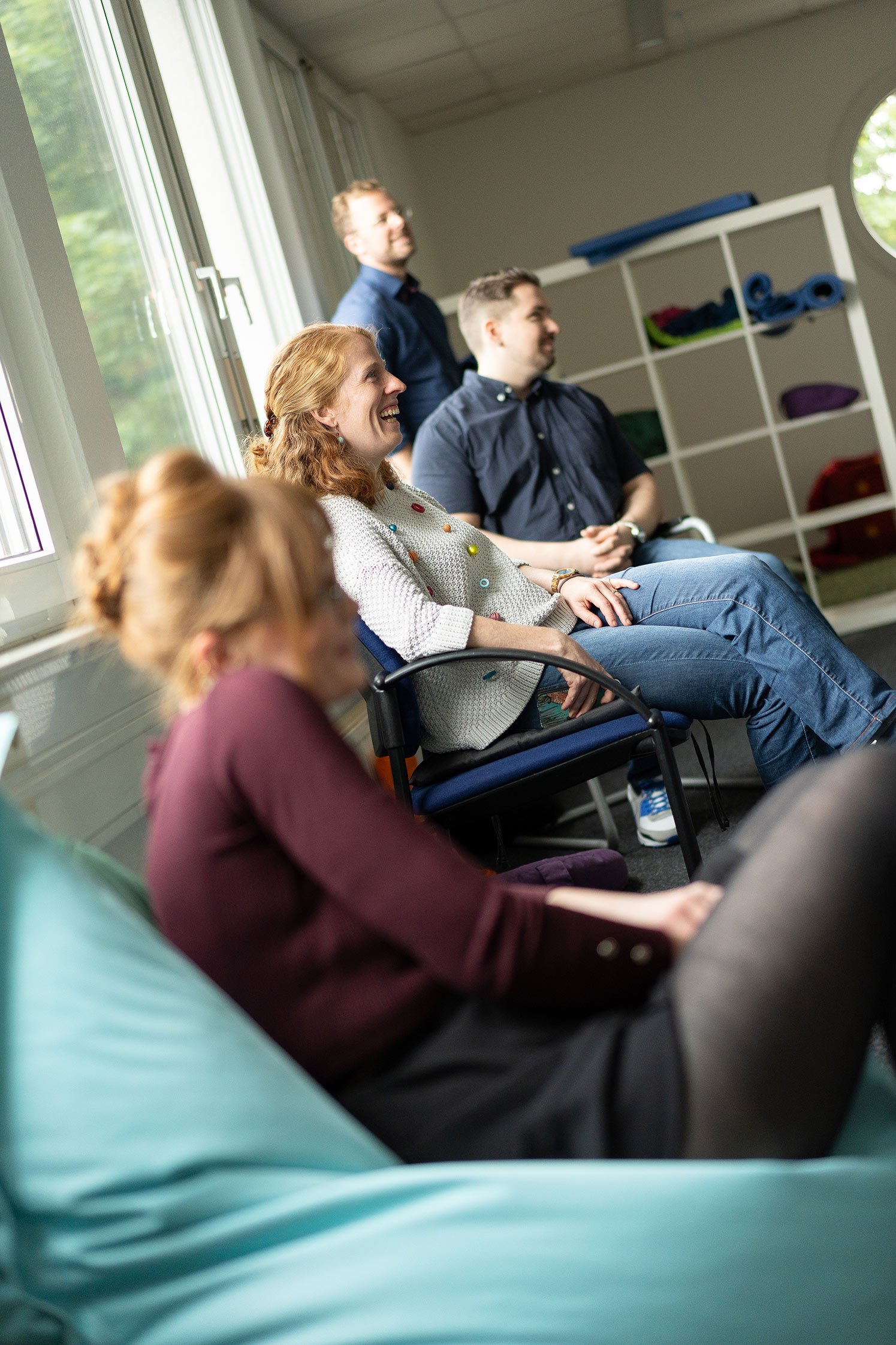 Fokus auf eine lachende APS-Mitarbeiterin im Teamtreffen